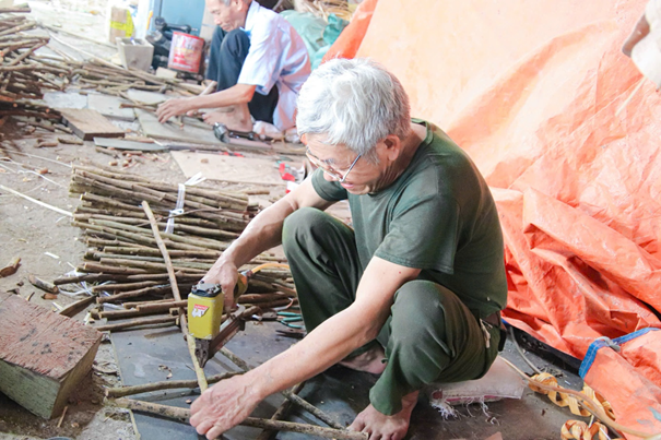 Đội ngũ thợ lành nghề lớn tuổi quây quần đan lát, tạo nên bầu không khí làm việc ấm cúng như một gia đình tại xưởng Giang Huyền