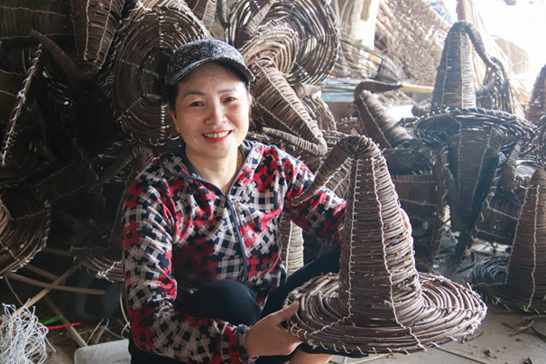 Chị Hoàng Thị Huyền (vợ anh Giang) tất bật đan lát cùng các thợ lành nghề ngay tại công xưởng
