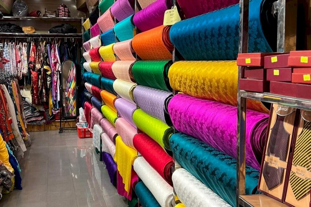 Người thợ đang vận hành khung dệt để tạo ra các sản phẩm lụa truyền thống nổi tiếng của làng Vạn Phúc.
