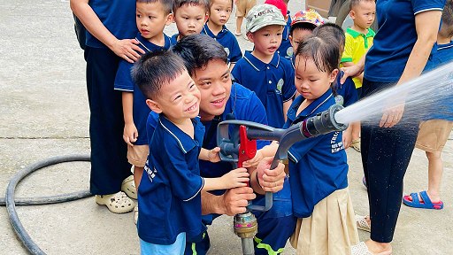 Các nụ cười bé xinh thể hiện rõ sự yêu thích khi được trải nghiệm phun nước chữa cháy