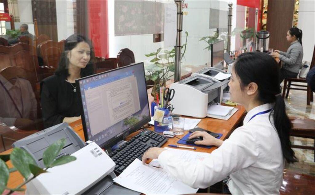 Cán bộ hành chính sử dụng hệ thống văn bản điện tử và cơ sở dữ liệu số để xử lý công việc hàng ngày.